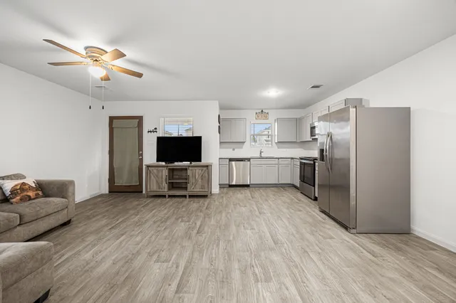 a living room with stainless steel appliances furniture and a fireplace
