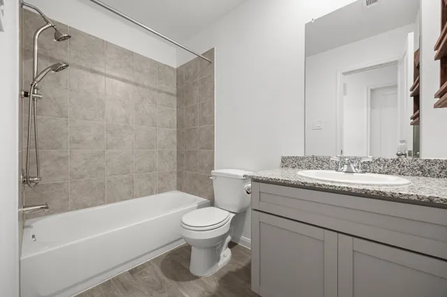 a bathroom with a granite countertop sink toilet and shower