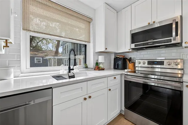 a kitchen with a sink stove and microwave