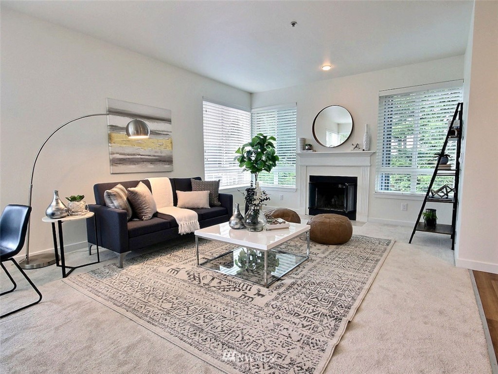 3903 243rd Place Southeast, Unit N202 Bothell, WA 98021 - Photo 3 of 34 a living room with furniture a fireplace a rug and a large window
