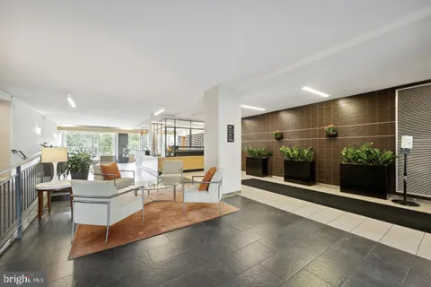 a living room with furniture a flat screen tv and a floor to ceiling window