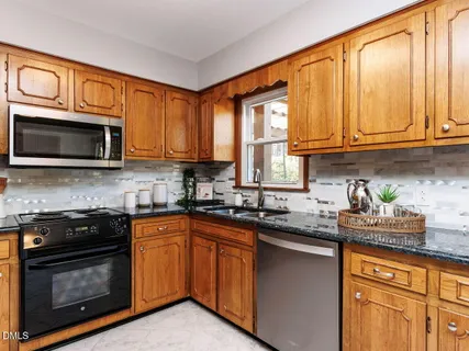 a kitchen with stainless steel appliances granite countertop a stove a sink dishwasher and a microwave