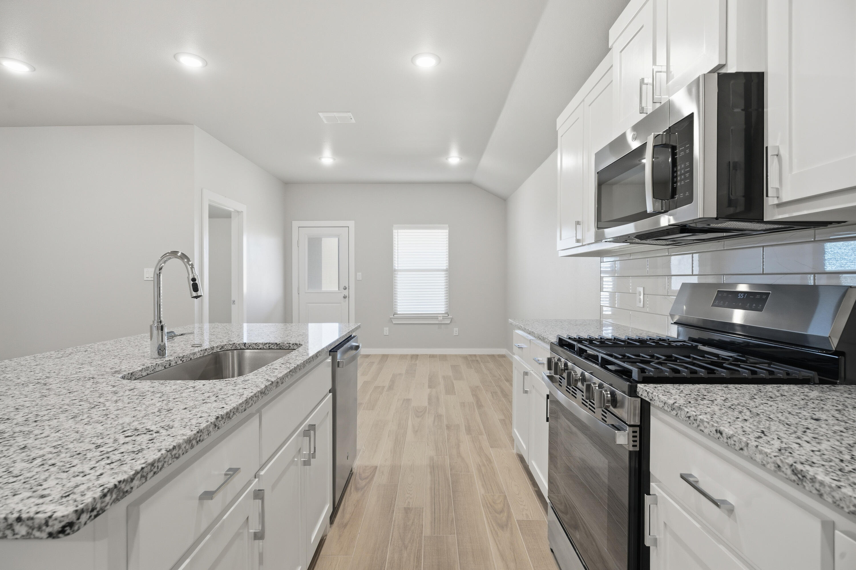 618 East 13th Street Wolfforth, TX 79382 - Photo 13 of 33 a kitchen with granite countertop stainless steel appliances a sink stove top oven and microwave
