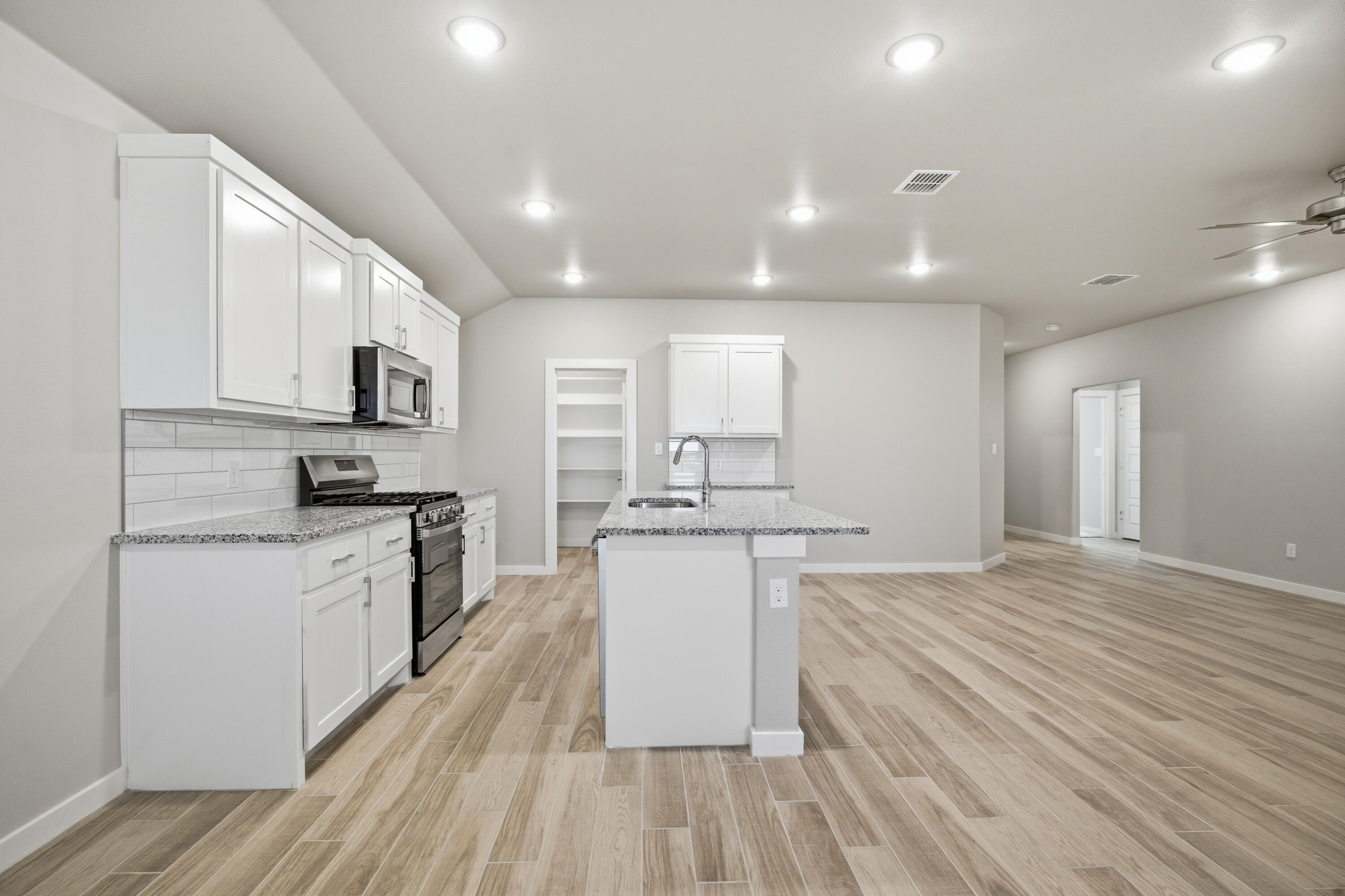 618 East 13th Street Wolfforth, TX 79382 - Photo 14 of 33 a large kitchen with stainless steel appliances granite countertop a stove and a sink