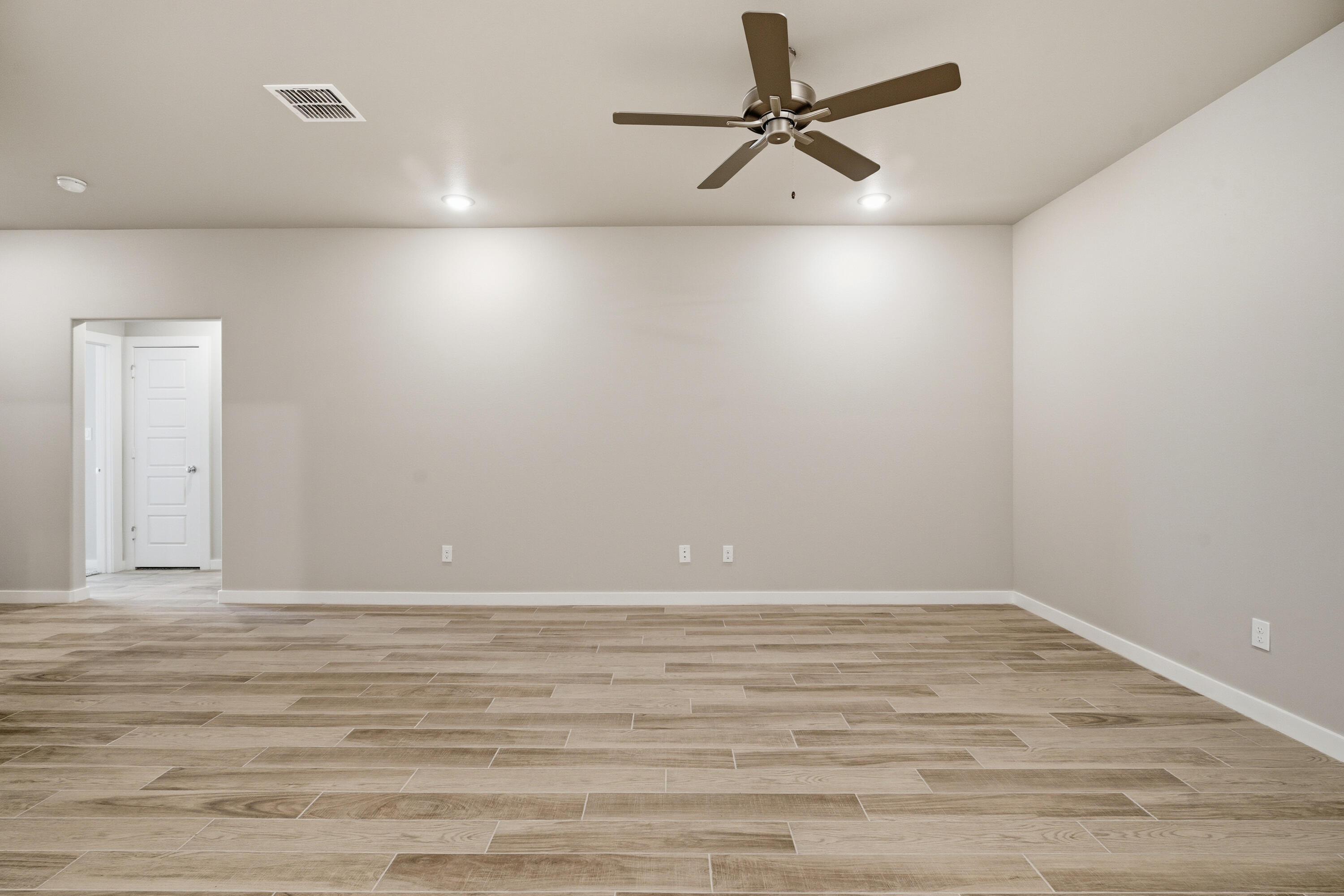 618 East 13th Street Wolfforth, TX 79382 - Photo 5 of 33 a view of a small space with wooden floor and a ceiling fan