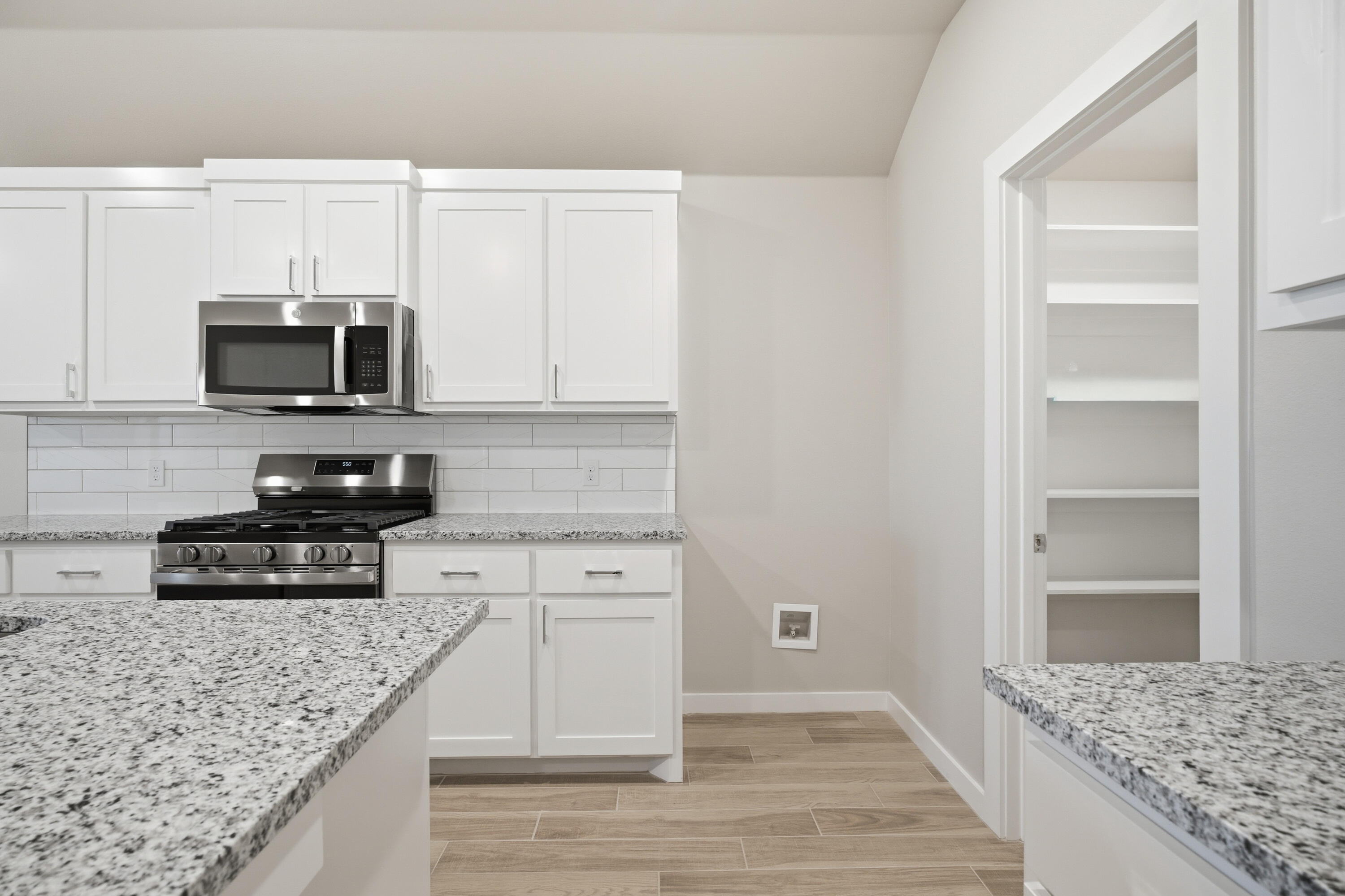 618 East 13th Street Wolfforth, TX 79382 - Photo 9 of 33 a kitchen with granite countertop a stove and a microwave