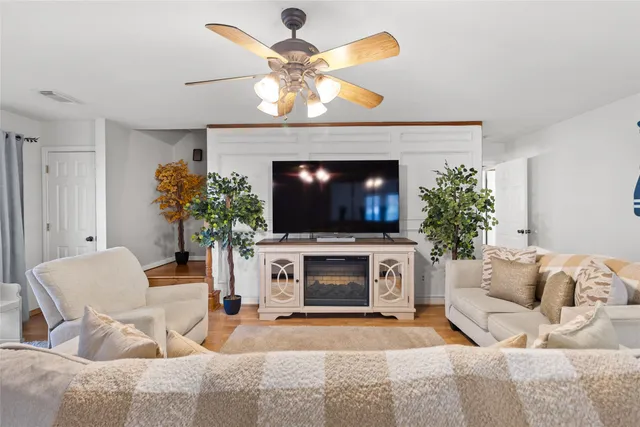 a living room with furniture a flat screen tv and a fireplace