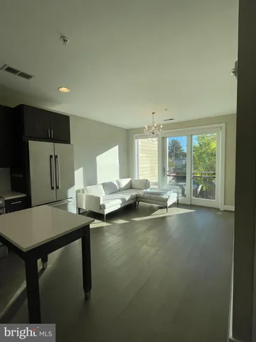 a room with a table chairs wooden floor and a large window