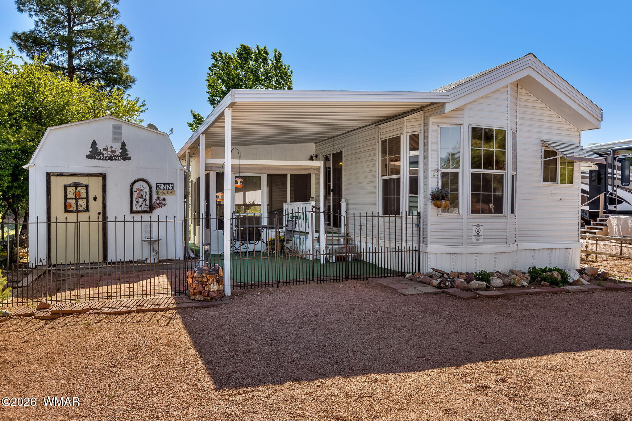 2725 Whiskey Road Overgaard, AZ 85933 - Photo 5 of 32 a view of a white house with large windows and a small yard