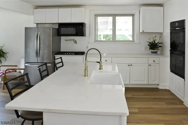 a kitchen with stainless steel appliances a microwave a sink a refrigerator and cabinets