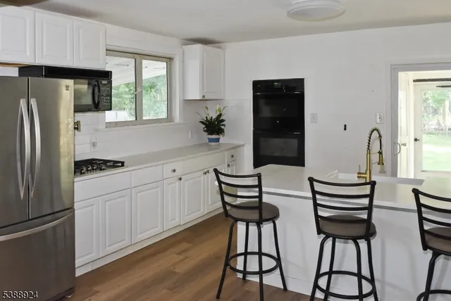 a kitchen with stainless steel appliances a refrigerator and a stove top oven