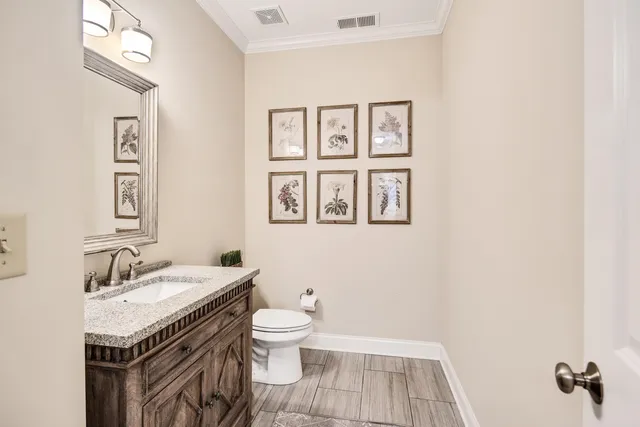 a bathroom with a granite countertop toilet a sink and a mirror