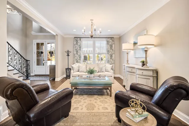 a living room with furniture a fireplace and a chandelier
