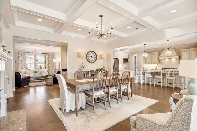 a view of a dining room and livingroom with furniture wooden floor a chandelier