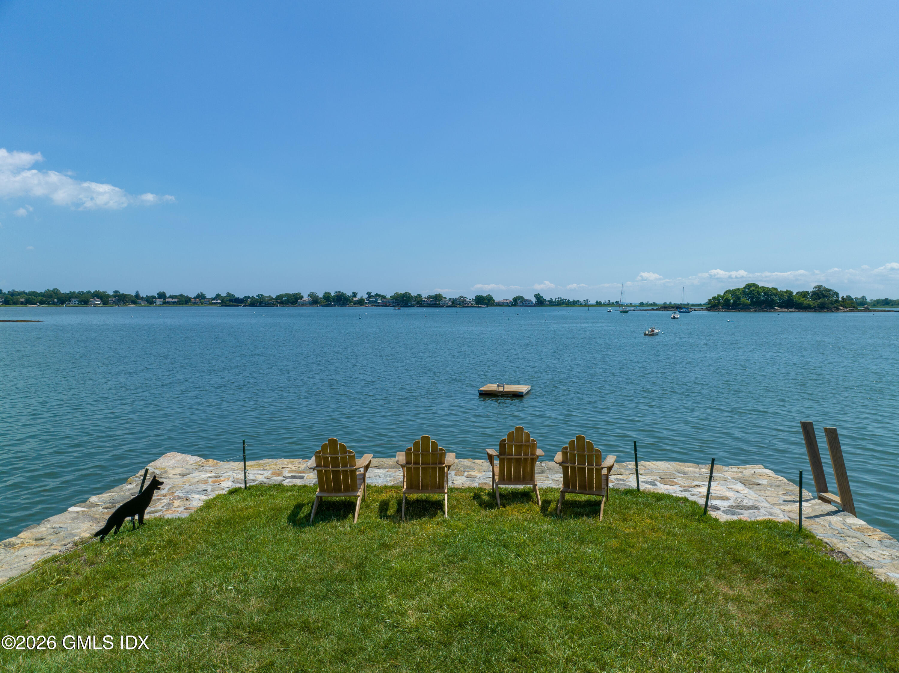 108 Cedar Cliff Road Riverside, CT 06878 - Photo 49 of 49 a view of a lake with a bench in front of it