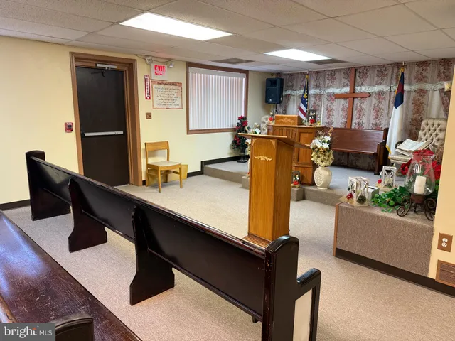 a living room with furniture pool table wooden floor and windows