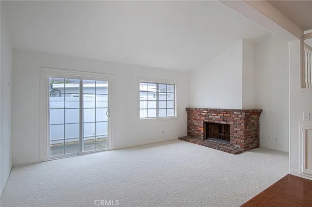an empty room with fireplace and windows