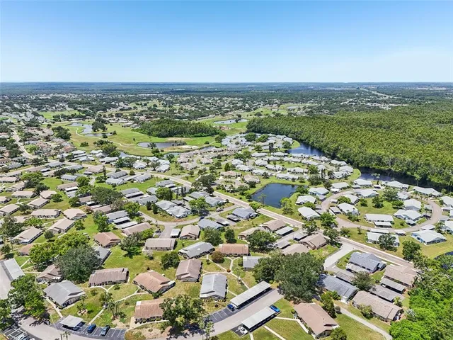 an aerial view of a residential houses with outdoor space and trees