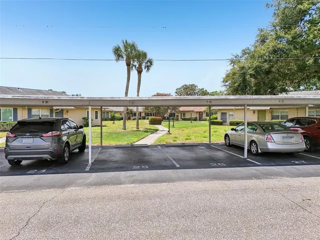 an aerial view of a residential apartment building with a yard and flowers