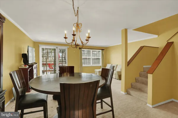 a dining room with furniture a chandelier and wooden floor