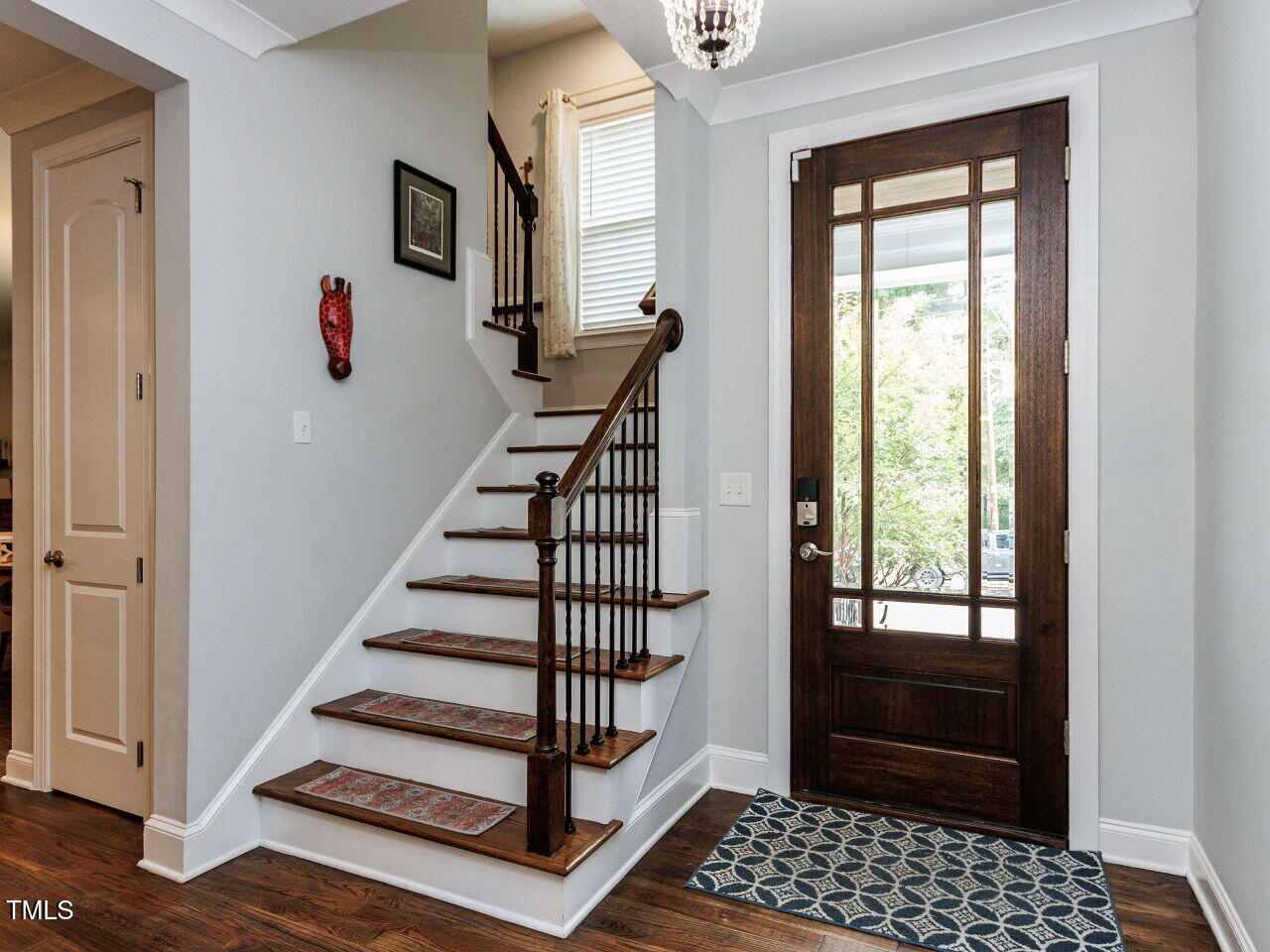 802 Lynn Road Durham, NC 27703 - Photo 5 of 41 Custom front door, welcoming staircase with wrought iron spindles, site finished hardwood flooring.