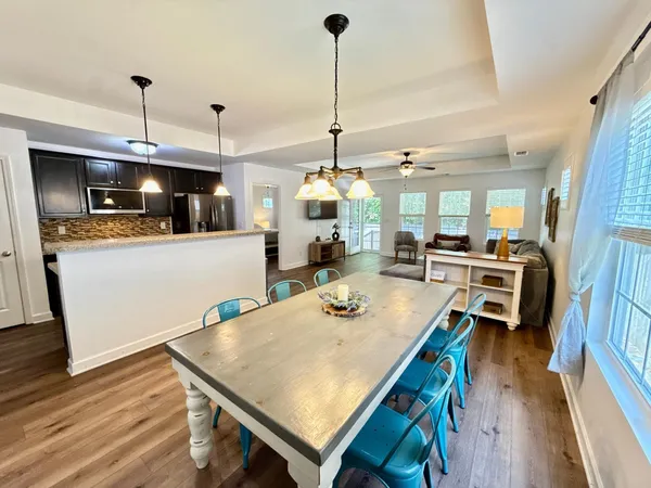a kitchen with stainless steel appliances wooden floor and refrigerator