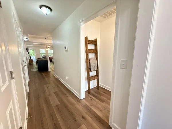 a view of a hallway with wooden floor and staircase