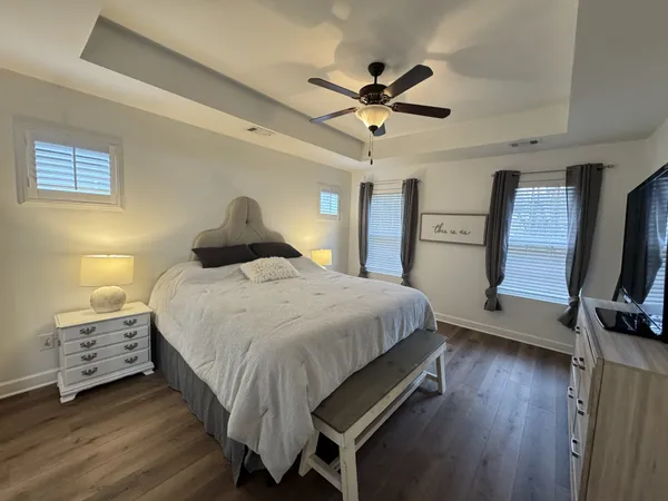 a large bedroom with a bed and a flat tv screen on dresser
