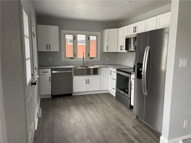 a kitchen with stainless steel appliances a refrigerator sink and microwave