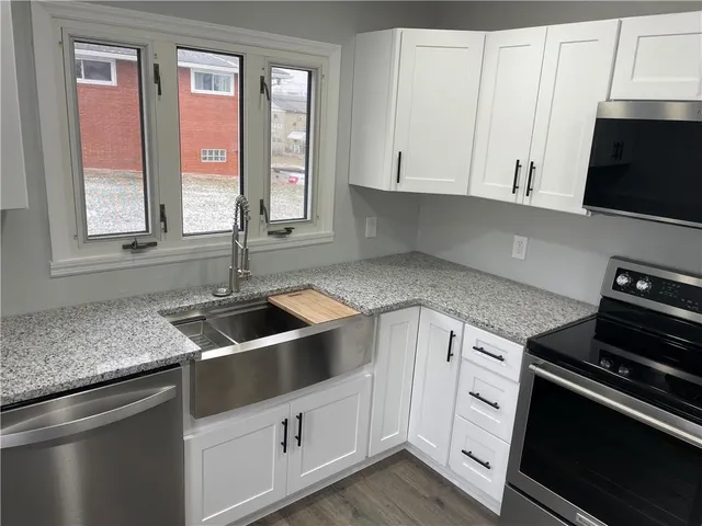 a kitchen with granite countertop a sink and a stove
