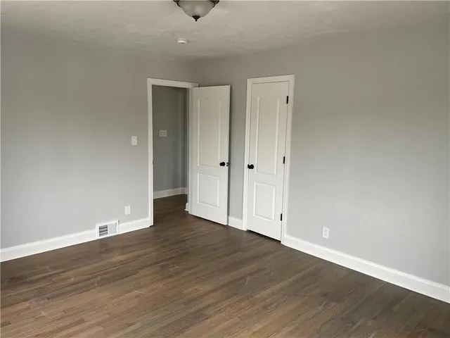 a view of an empty room with wooden floor
