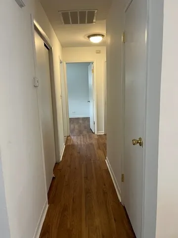 a view of a hallway with wooden floor
