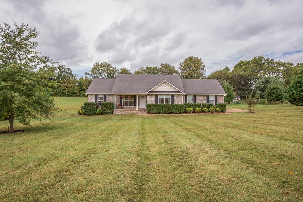 a front view of house with yard and swimming pool
