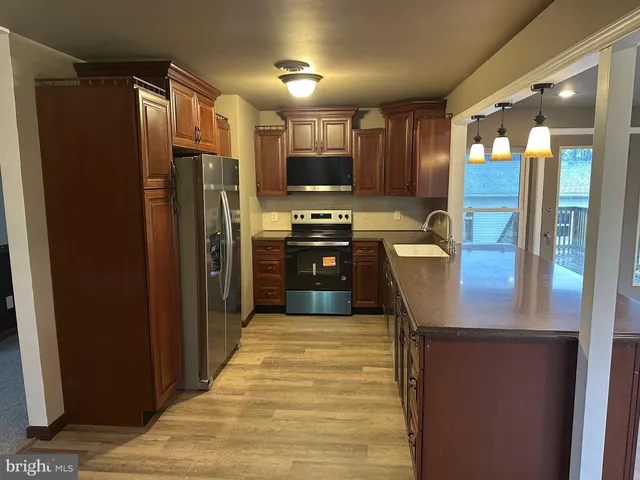 a kitchen with stainless steel appliances granite countertop a refrigerator and a sink