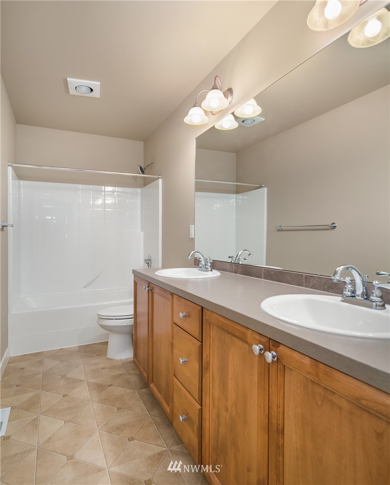 5639 Northeast 7th Place Renton, WA 98059 - Photo 19 of 23 a bathroom with a sink a toilet and a large mirror