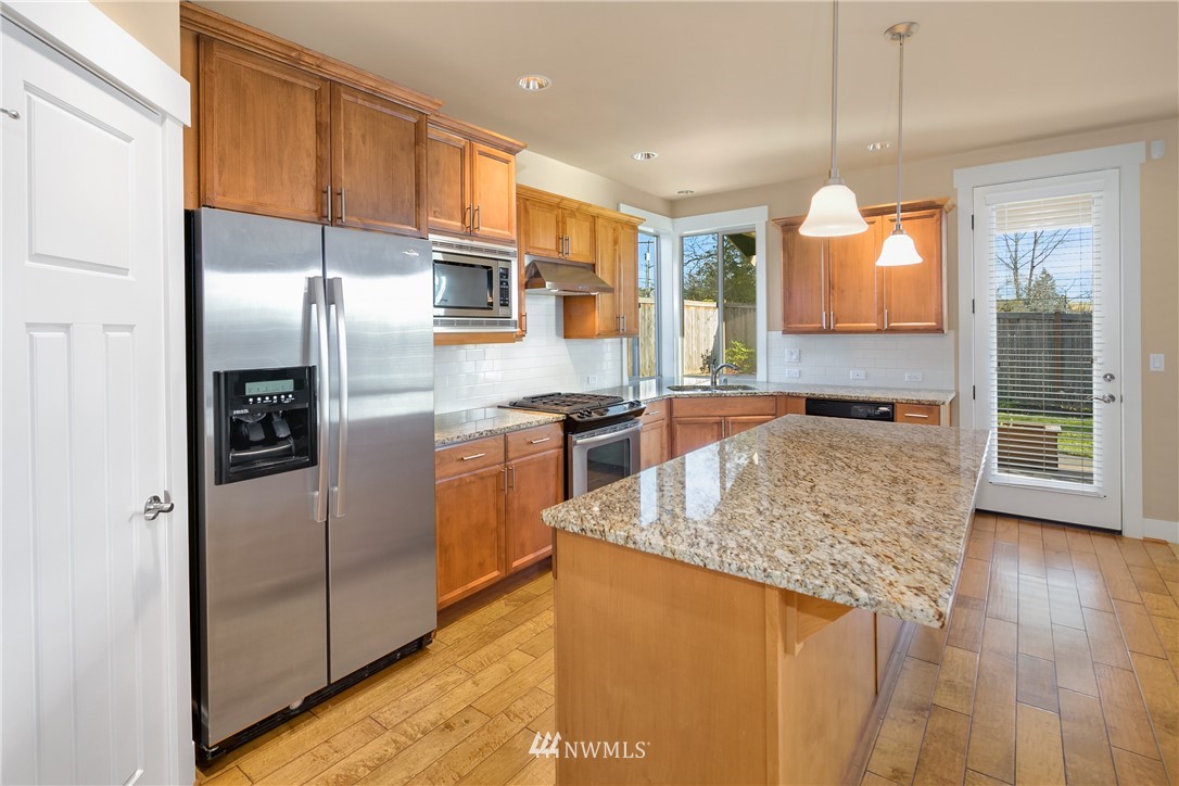5639 Northeast 7th Place Renton, WA 98059 - Photo 7 of 23 a kitchen with stainless steel appliances granite countertop a refrigerator a oven a sink and a oven