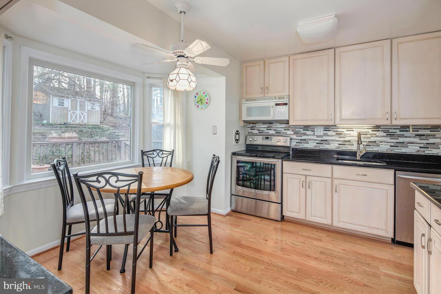 4106 Delancy Drive Silver Spring, MD 20906 - Photo 9 of 30 a kitchen with stainless steel appliances granite countertop a stove a sink a microwave a dining table and chairs