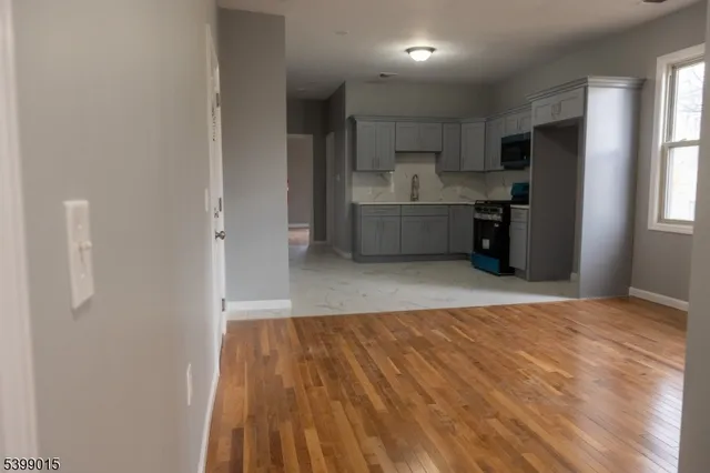 a view of a kitchen with wooden floor and electronic appliances