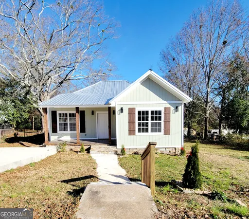 a front view of a house with a yard covered in snow