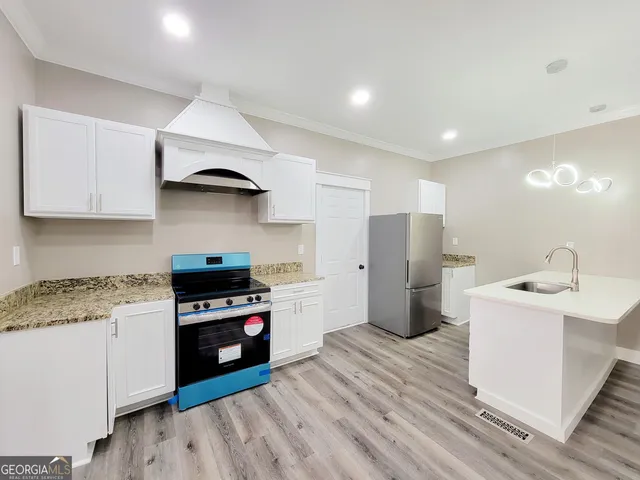 a kitchen with a sink a stove and refrigerator