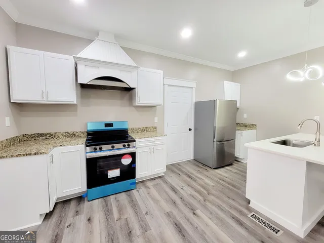 a kitchen with a stove a sink and a refrigerator