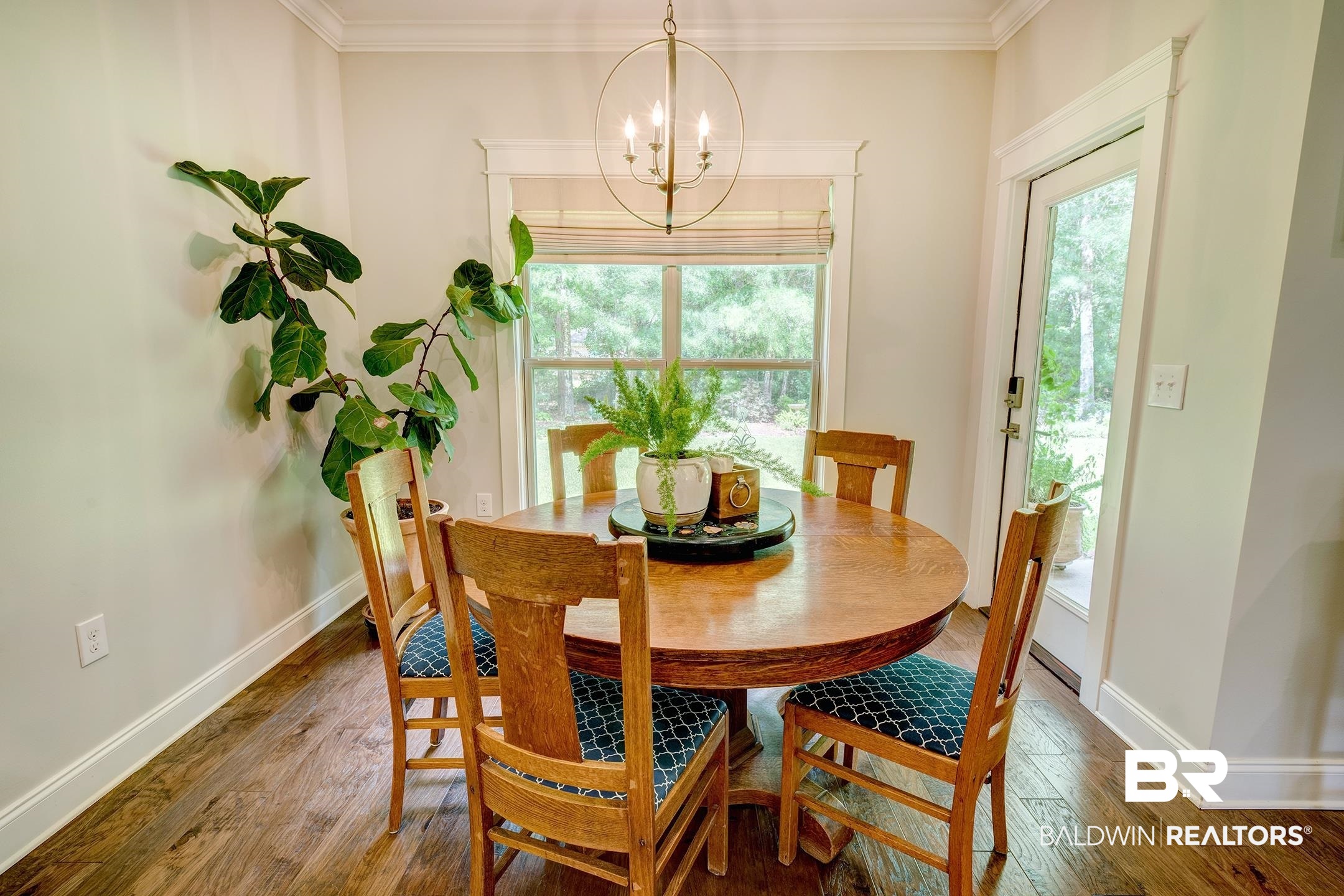 18754 Treasure Oaks Road Gulf Shores, AL 36542 - Photo 30 of 53 Dining area featuring wood-finish flooring, a full-lite exterior door, and a window with a woven shade