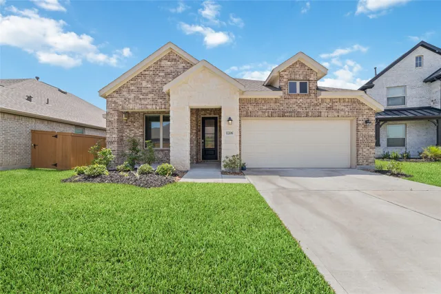 a front view of a house with a yard and garage
