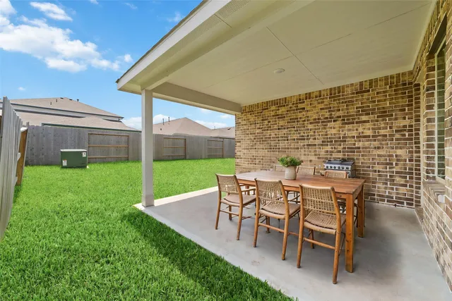 a patio with table and chairs and garden