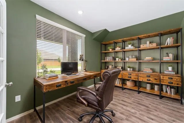 a view of a workspace with furniture and a bookshelf