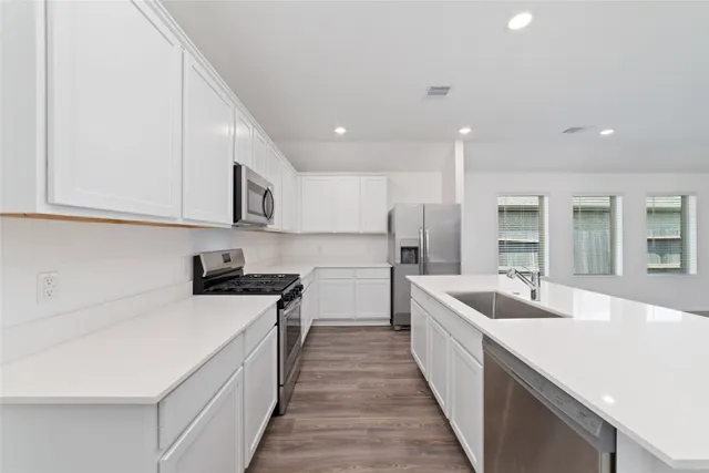a kitchen with counter top space a sink stainless steel appliances and cabinets