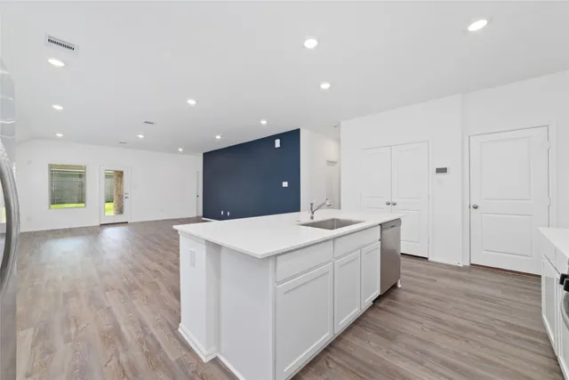a kitchen with a sink and wooden floor