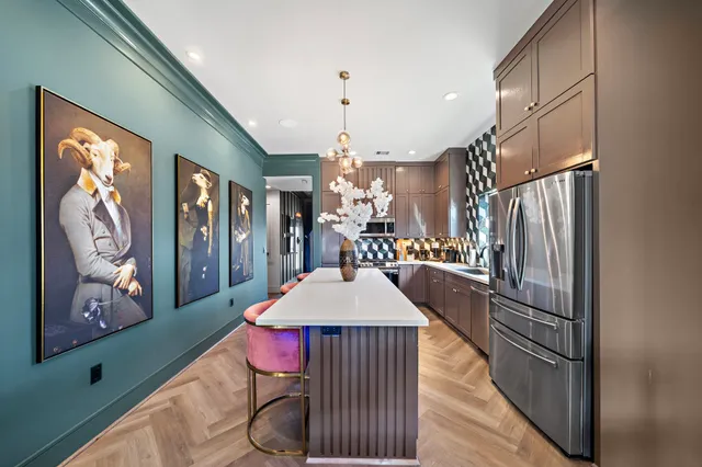 a kitchen with a refrigerator a stove and wooden floor