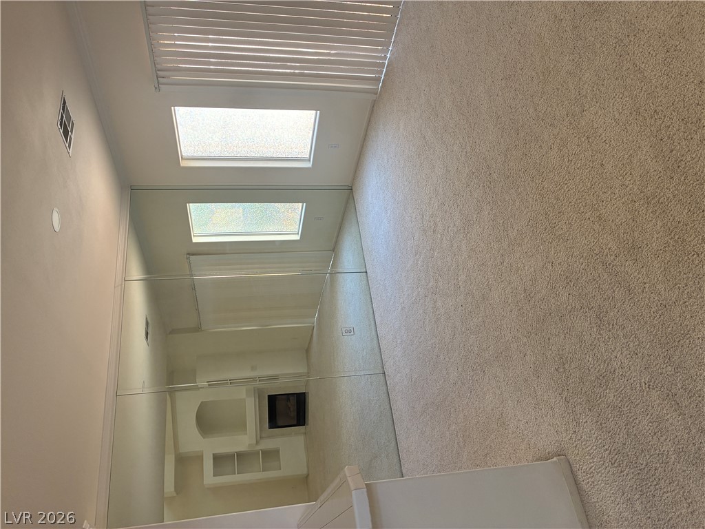 5272 Island Chain Road Las Vegas, NV 89118 - Photo 20 of 39 Natural light floods this inviting space, complemented by plush carpeting and built-in shelving. A floor to ceiling wall of mirrors adds tons of light and visually elongates the space.