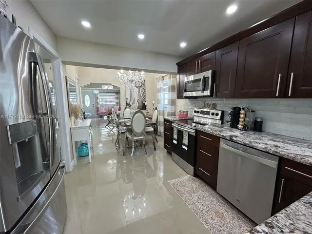 a kitchen with stainless steel appliances granite countertop a refrigerator stove microwave and sink